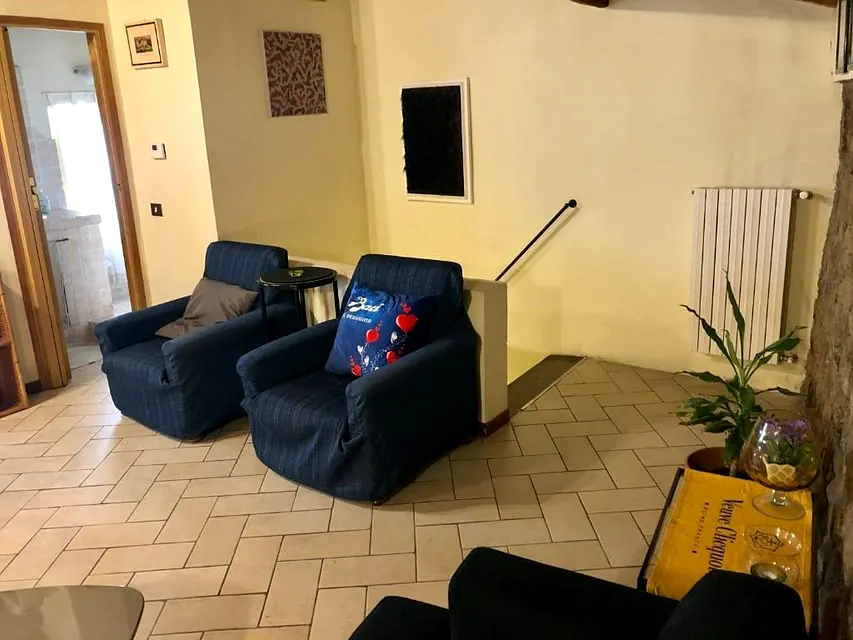 Area relax con poltrone blu e dettagli artistici nell'appartamento